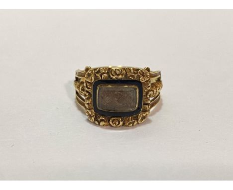 An early 19th century enamel and gold (untested) mourning ring, the glazed compartment containing a lock of plaited hair, wit