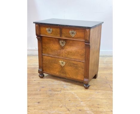 A late 19th century French walnut commode in the Empire taste, the black variegated marble top over three drawers with cast g
