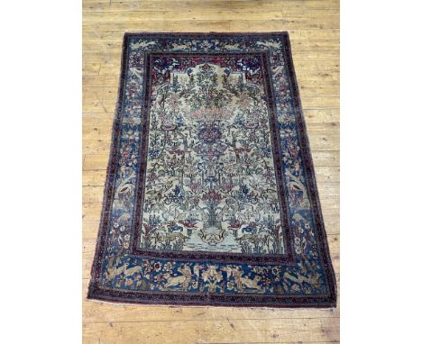 A fine Persian paradise garden rug, hand knotted, the central panel depicting the tree of life on an ivory field framed withi