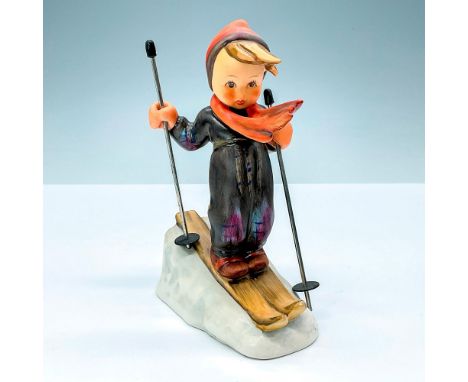 A matte finished skier figurine, ready to conquer the steep descent below, colored in vibrant orange and brown hues. Goebel b