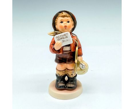 Hand painted newspaper boy with headlines of the Zeppelin. Goebel backstamp. M.I. Hummel impressed mark. 569. This item has i