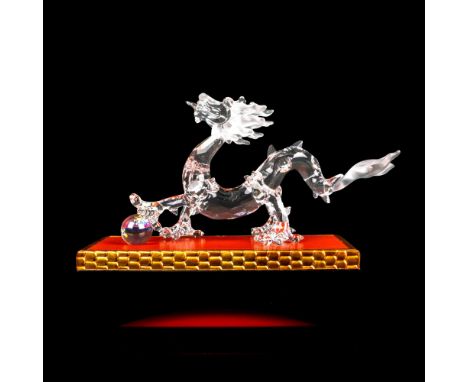 Lead crystal dragon made with frosted crystal tail. It sits with its crystal ball on base. Swarovski etched backstamp. This i