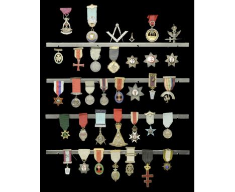 A framed display of 35 mainly Masonic Jewels, the centrepiece being a silver Masonic Square and Compass inlaid with 32 paste 