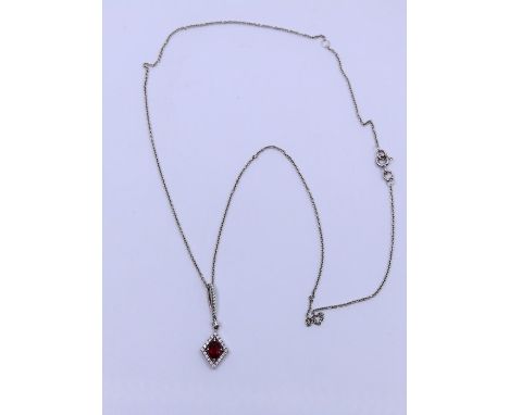 A white gold pendant , set with central ruby with similar chain&nbsp;
