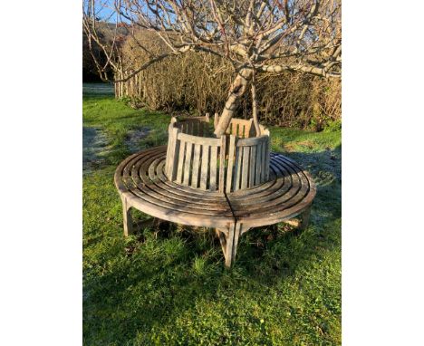 A slatted weathered teak sectional tree surround bench, approx. diameter 190cm, height 87cm. Condition - fair