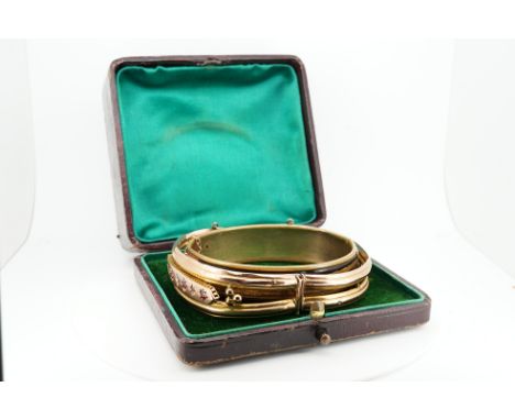 An Edwardian 9ct gold, and gypsy set ruby and diamond set hinged bangle, gross 11.4 grams, together with a gilt metal hinged 