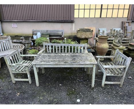 A slatted weathered teak rectangular garden table, width 149cm, depth 70cm, height 68cm, a bench and two armchairs. Condition