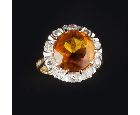 A CITRINE AND DIAMOND CLUSTER RING, the circular mixed-cut citrine claw set within a border of round brilliant-cut diamonds, 
