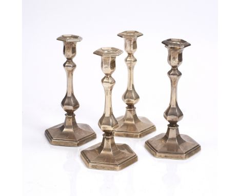 A SET OF FOUR SCOTTISH SILVER HEXAGONAL CANDLESTICKS with baluster columns, Edinburgh 1918 by Hamilton and Inches, 26cm high