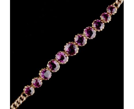 A RUBY LINE BRACELET, the line of graduated oval mixed-cut rubies in pierced claw settings, to a curb-link back chain with fi