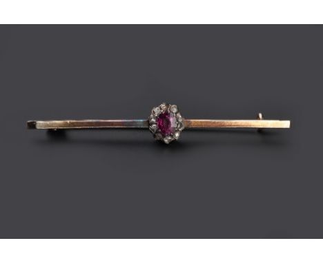 A RUBY AND DIAMOND BAR BROOCH, the oval mixed-cut ruby claw set within a border of lasque-cut diamonds, to a uniform bar, len