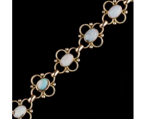 AN OPAL PANEL BRACELET, the openwork quatrefoil panels with bead accents, each centred with an oval cabochon opal in closed-b