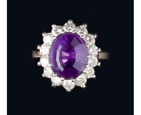 AN AMETHYST AND DIAMOND CLUSTER RING, the oval mixed-cut amethyst claw set within a border of round brilliant-cut diamonds, 1