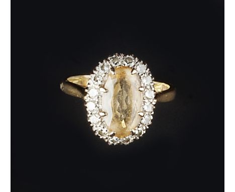 A YELLOW TOPAZ AND DIAMOND CLUSTER RING, the oval mixed-cut yellow topaz claw set within a border of round brilliant-cut diam