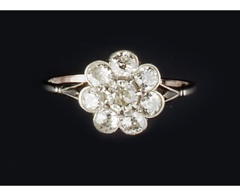A DIAMOND CLUSTER RING, the flowerhead cluster of brilliant and old-cut diamonds in claw and millegrain collet settings, betw