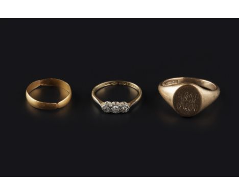 THREE RINGS, comprising a diamond three stone ring, stamped '18ct plat', a 9ct gold signet ring, monogrammed, and a 22ct gold