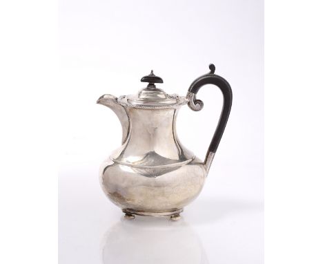 A SILVER BALUSTER SHAPED OVAL COFFEE POT with shell and gadrooned decoration, domed hinged lid, bun feet and ebonised wooden 