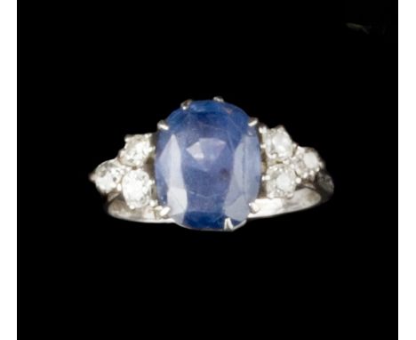 A SAPPHIRE AND DIAMOND DRESS RING, the oval mixed-cut sapphire claw set between trios of old-cut diamonds, white precious met