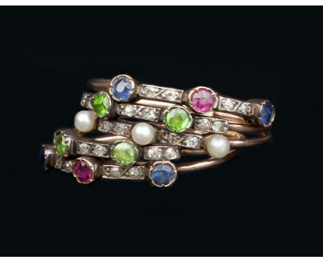 A LATE 19TH/EARLY 20TH CENTURY VARI GEM-SET HALF HOOP RING, comprising five connected bands of stacked design, alternately se