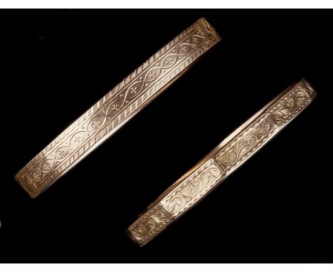 TWO 9CT GOLD SLAVE BANGLES, the first of panelled form, with engraved foliate decoration, the second of continuous form, also