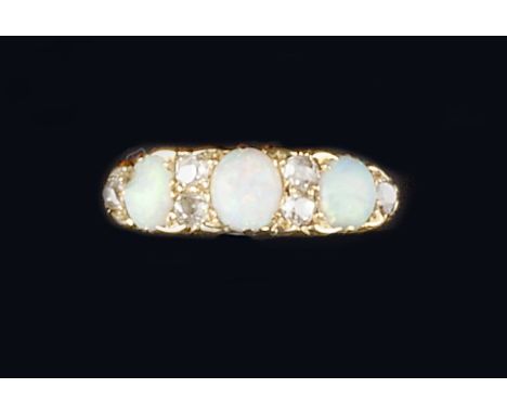 AN OPAL AND DIAMOND HALF HOOP RING, the trio of oval cabochon opals spaced by old-cut diamonds, to a scroll engraved mount, y