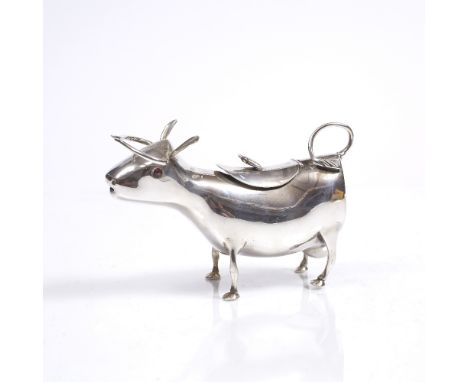 AN 18TH CENTURY STYLE SILVER COW CREAMER with bee finial and red glass eyes, 14cm long, 4.5 ozs