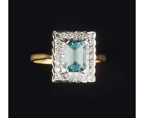 A BLUE ZIRCON AND DIAMOND CLUSTER RING, the rectangular step-cut zircon claw set above a border of single-cut diamonds, two c
