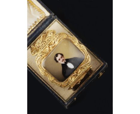 A VICTORIAN FILIGREE BANGLE, of articulated tapered form, centred with a rectangular portrait panel of a gentleman, in fitted