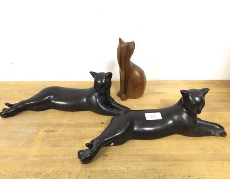 A pair of ceramic table sculptures in the form of Reclining Cats (each: 13cm x 38cm x 10cm) and a carved wooden Seated Cat (3