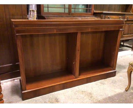 A modern open bookshelf, the rectangular top above a reeded frieze, with two shelf recesses with central divider, on plinth b