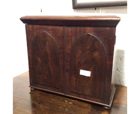 A 19thc mahogany table cabinet, with moulded top above a pair of Gothic style doors, fitted single adjustable shelf to interi