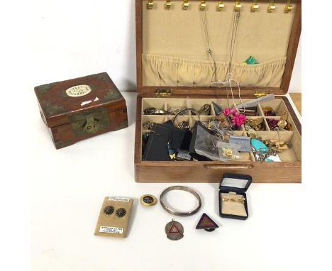 An assortment of costume jewellery including earrings, white metal bangle, badges, necklaces etc., and a wooden box with bras