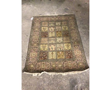 A North West Persian rug, the central field with twenty four panels, each with foliate design, within a flowerhead border wit