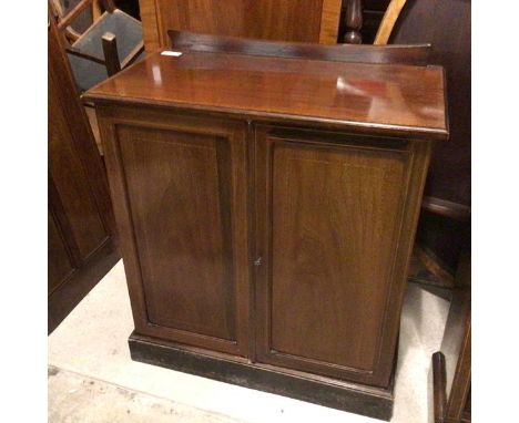 An Edwardian mahogany cupboard, with a concave ledgeback above an inlaid moulded top above two doors with single shelf to int