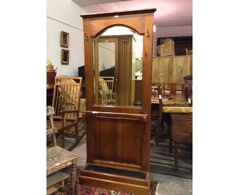 A modern hallstand with moulded cornice above a domed bevelled mirror, with two hanging hooks, above stick rail and drip pan,