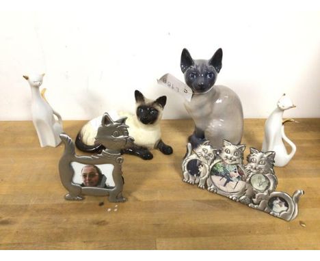 A Royal Copenhagen Siamese cat (19cm) and a Royal Doulton Reclining Siamese Cat, two other ceramic cat figures and two photog