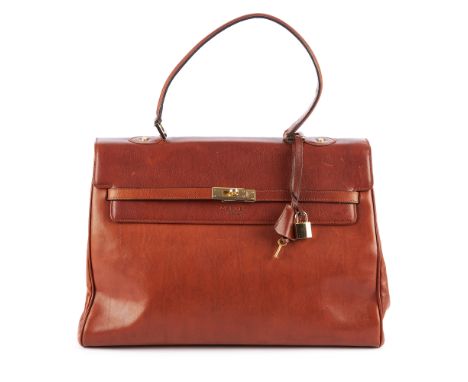 Osprey, a tan leather handbag, featuring gold-tone hardware, single leather top handle, crossover straps and a turn-lock fast