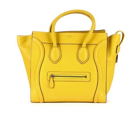 Celine, a Mini Luggage tote, designed with a grained yellow leather exterior, featuring expandable leather side wings, a fron