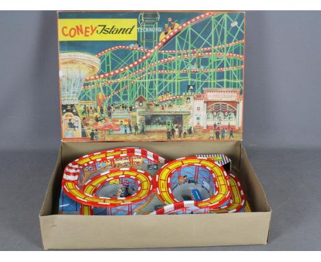 Technofix - A boxed plastic and tinplate Coney Island amusement park with 2 x clockwork coaches. The track is in Very Good co