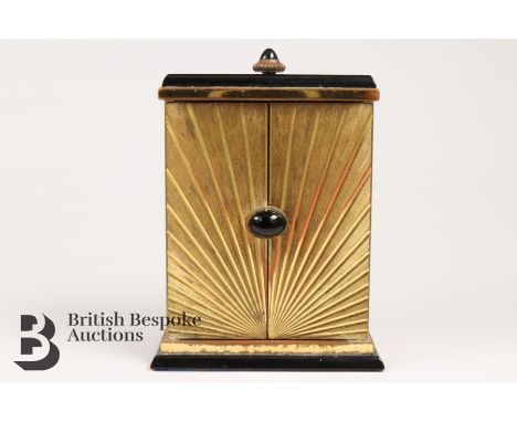 Art Deco Cartier miniature carriage clock. The clock having a gilded case with cabochon winder, having a white enamel engine-