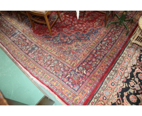 An Indo Persian small carpet with a red ground