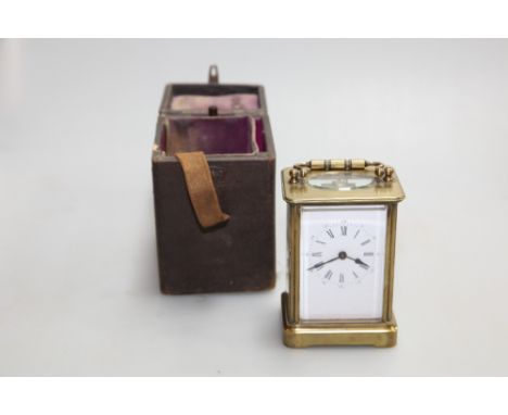 A small brass carriage clock and key, height 11cms,  in travelling case, 