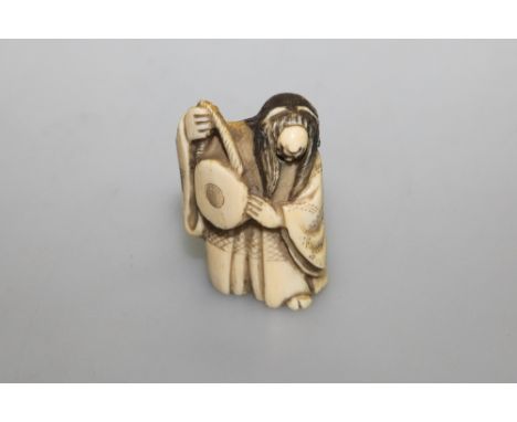 A carved double faced netsuke of a musician, 