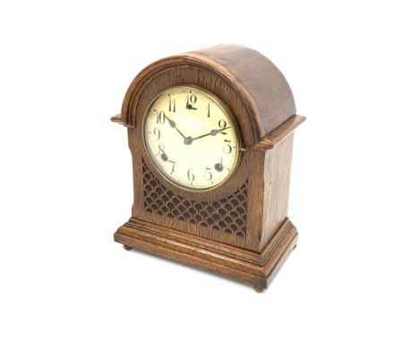 Early 20th century American oak cased mantel clock, arched hood, blind fret work detail, raised on brass feet, the ivorine di