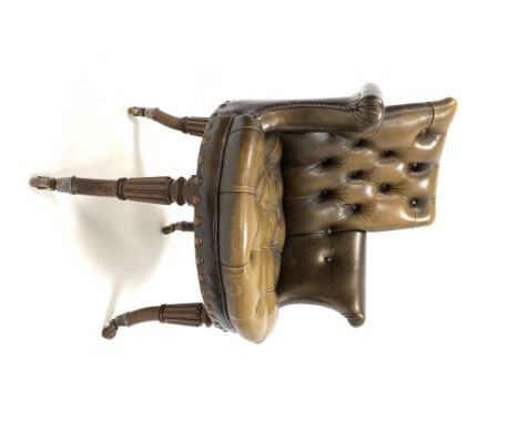 19th century mahogany framed library chair upholstered in deep buttoned brown leather, raised on out swept turned tapered and