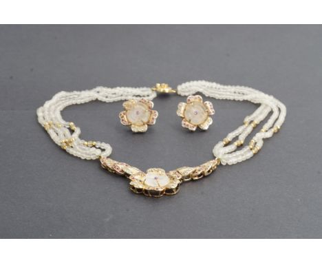 A yellow metal, ruby and rock crystal demi parure, comprising necklace and stud earrings, each in the form of a flower head, 