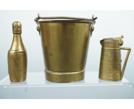Two novelty brass vesta cases, modelled as a bottle of 'Veuve Cliquot' and a water pitcher, together with a vesta pot modelle