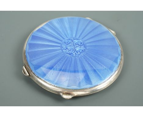 A George VI enamelled silver powder compact, of lenticular form, the face pale blue basse tailles enamelled over bat's wing /