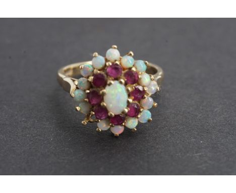 A vintage opal and ruby flower head cluster cocktail ring, in a tiered arrangement with central oval cabochon of approximatel