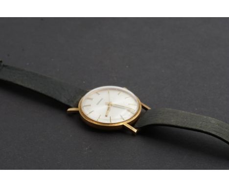 A 1970s Garrard 9 ct gold wrist watch, having a manual movement with circular radially-brushed silver face, gilt baton marker